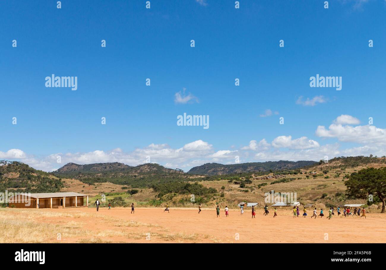 Bambini che giocano a calcio vicino a una scuola nel distretto di Mzimba, Malawi Foto Stock