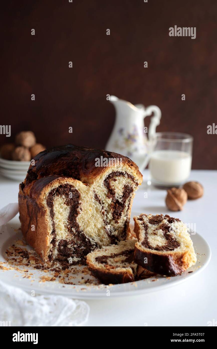 Pane dolce rumeno tradizionale fatto in casa chiamato 'cozonac', con cacao, uvetta e noci. Dessert da forno dell'Europa orientale. Babka. Foto Stock