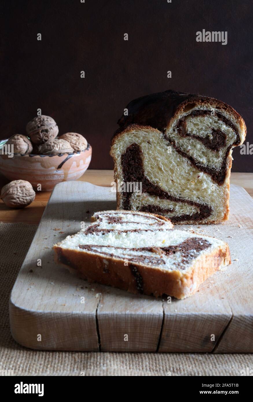 Pane dolce rumeno tradizionale fatto in casa chiamato 'cozonac', con cacao, uvetta e noci. Dessert da forno dell'Europa orientale. Babka. Foto Stock