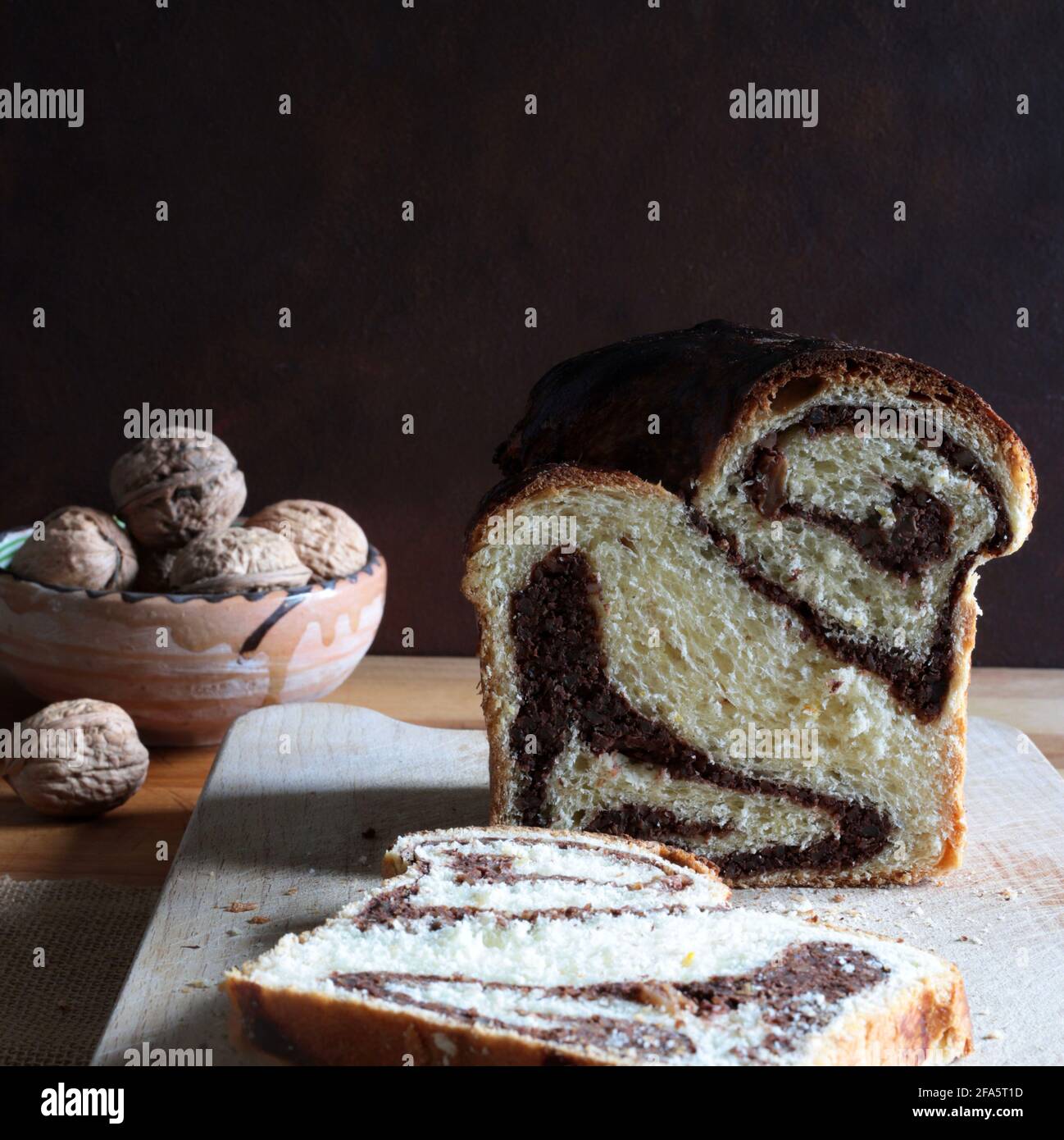 Pane dolce rumeno tradizionale fatto in casa chiamato 'cozonac', con cacao, uvetta e noci. Dessert da forno dell'Europa orientale. Babka. Foto Stock