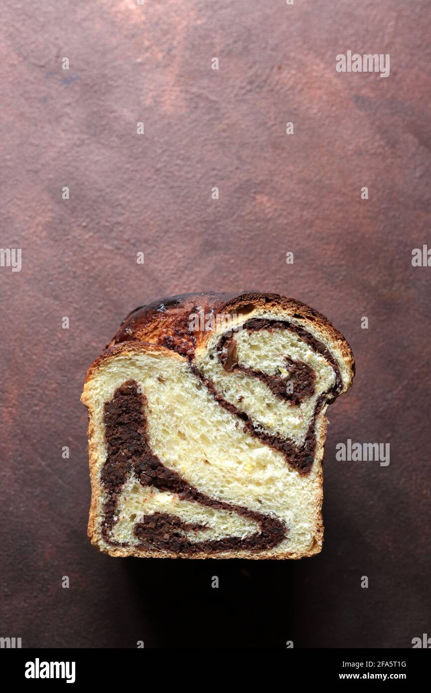 Pane dolce rumeno tradizionale fatto in casa chiamato 'cozonac', con cacao, uvetta e noci. Dessert da forno dell'Europa orientale. Babka. Foto Stock