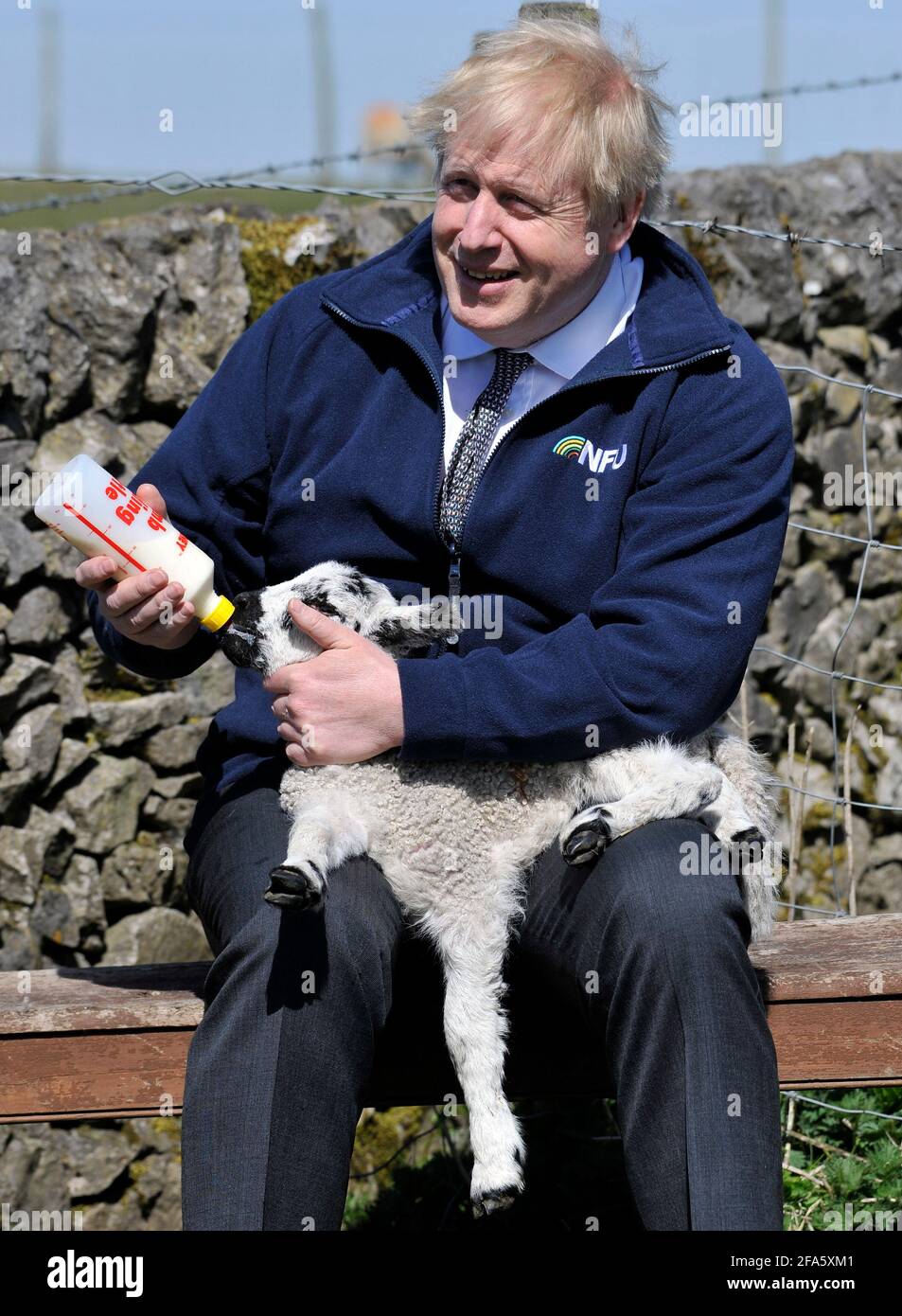 Il primo ministro Boris Johnson nutre un agnello durante una visita alla fattoria di Moor a Stoney Middleton, nel Derbyshire settentrionale, lungo il percorso elettorale locale. Data immagine: Venerdì 23 aprile 2021. Foto Stock