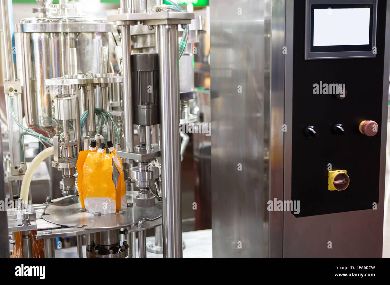 Macchina per il confezionamento di liquidi alimentari. Riempitrice con astuccio per succo d'arancia. Industria alimentare Foto Stock