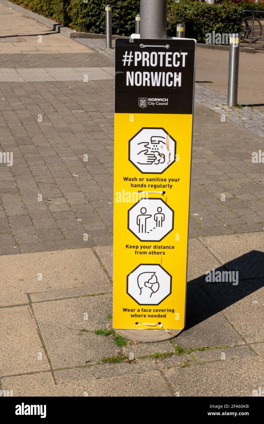 lampione centrale della città di norwich con una carta nera e gialla per striscioni hashtag legata ad essa. Con guide Covid 19 Foto Stock
