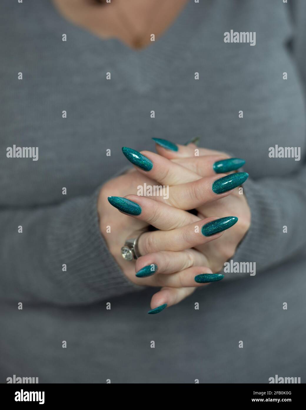 Mano femminile con unghie lunghe e manicure verde turchese con bottiglie di  smalto per unghie Foto stock - Alamy