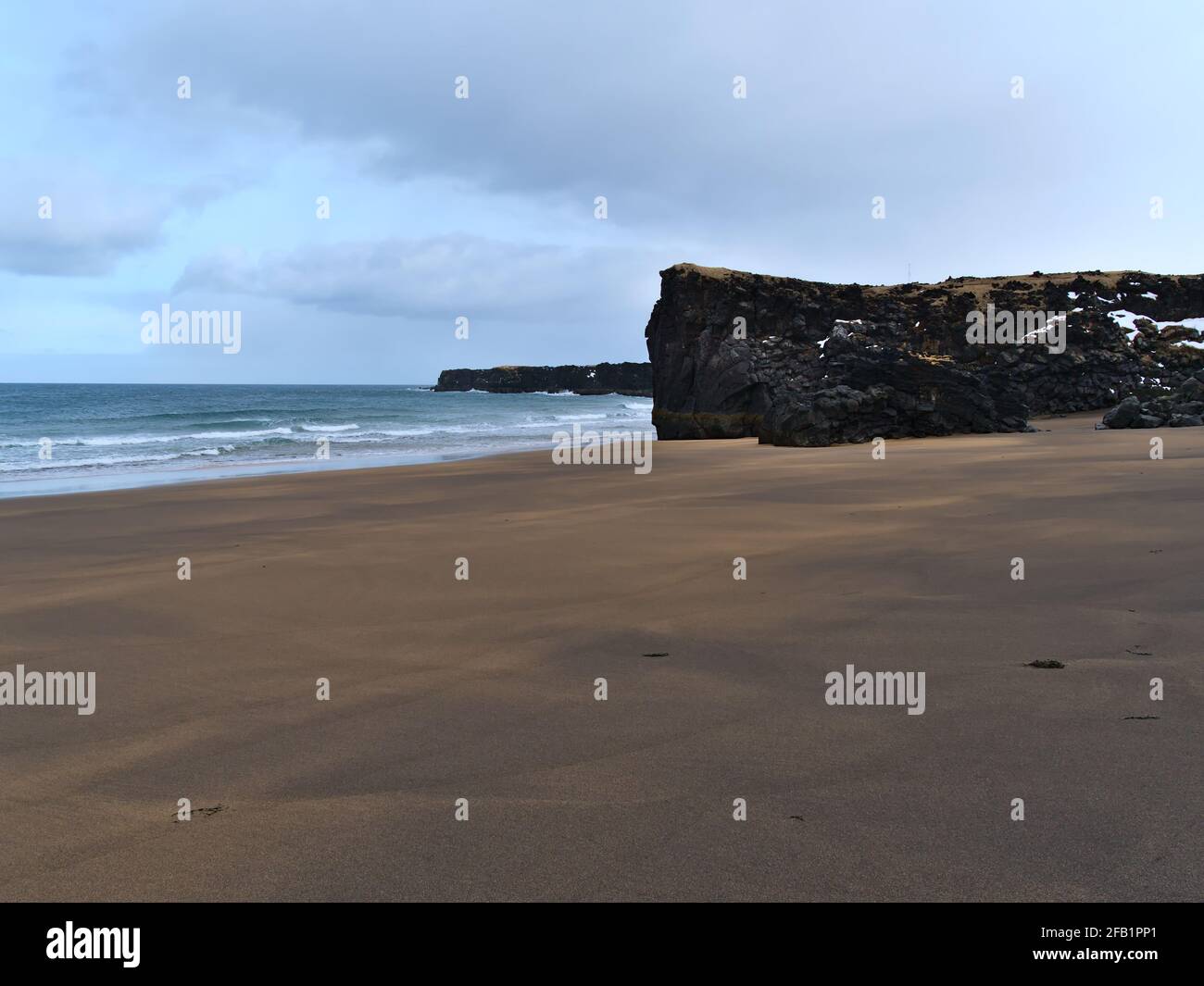 Splendida vista sulla spiaggia vulcanica di Skarðsvík con sabbia dorata, onde e scogliere di roccia nera sulla costa settentrionale di Snæfellsnes, Islanda. Foto Stock