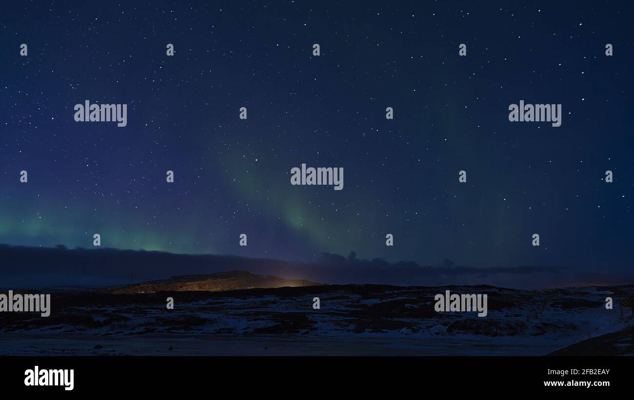 Splendida luce polare verde scintillante (aurora borealis) nel cielo notturno scuro e stellato sopra la penisola di Snæfellsnes, nell'Islanda occidentale nella stagione invernale. Foto Stock
