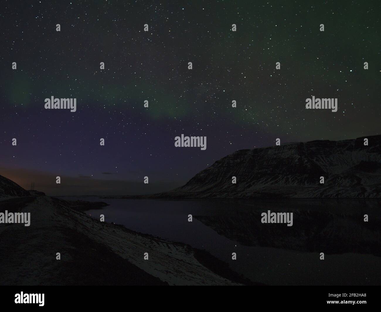 Vista mozzafiato delle luci verdi scintillanti del nord (aurora borealis) nel cielo notturno scuro e stellato sopra il fiordo di Álftafjöður, Snæfellsnes, Islanda. Foto Stock