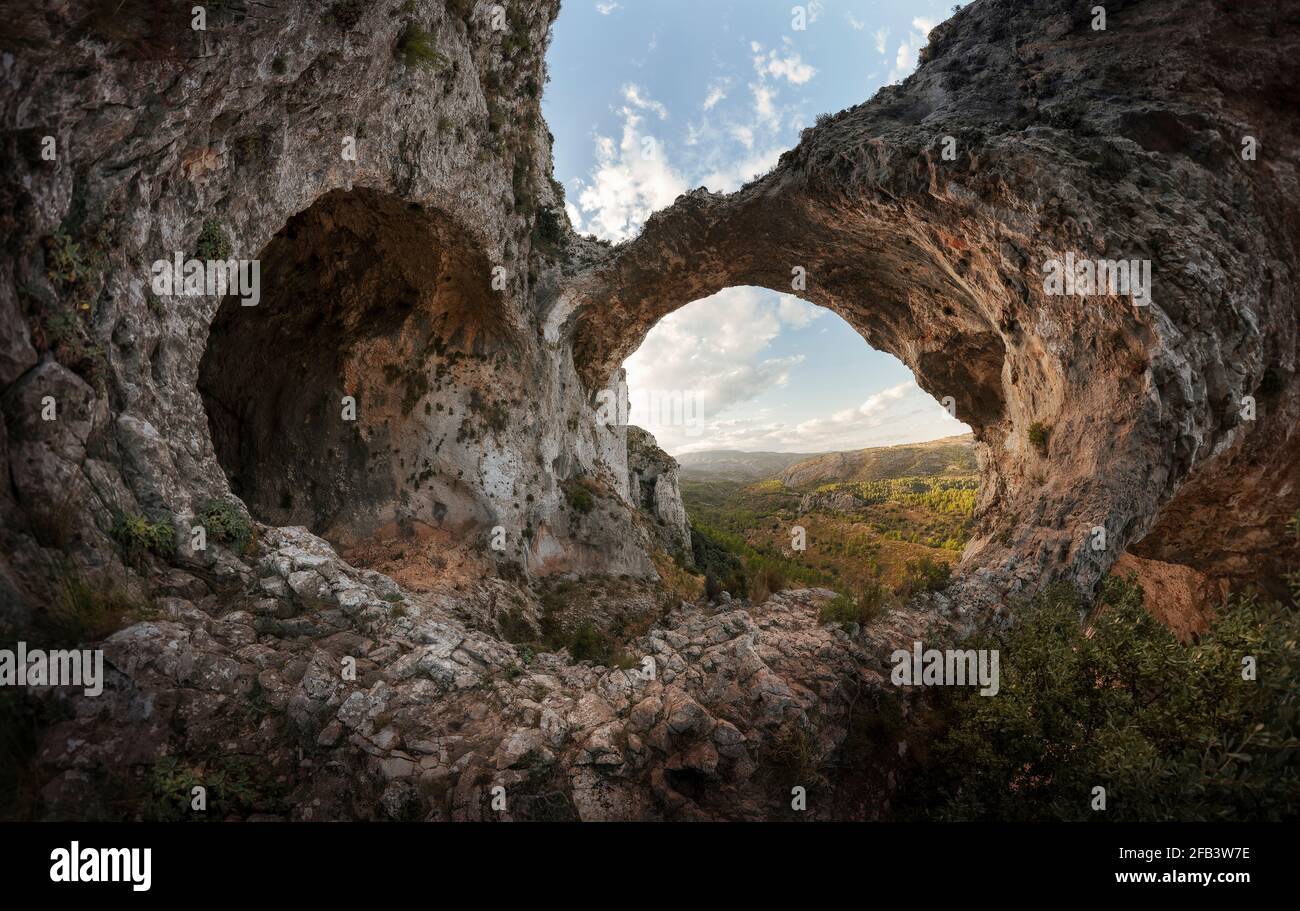 Un'antica grotta e un arco di roccia formano l'immagine di un cuore di pietra Foto Stock