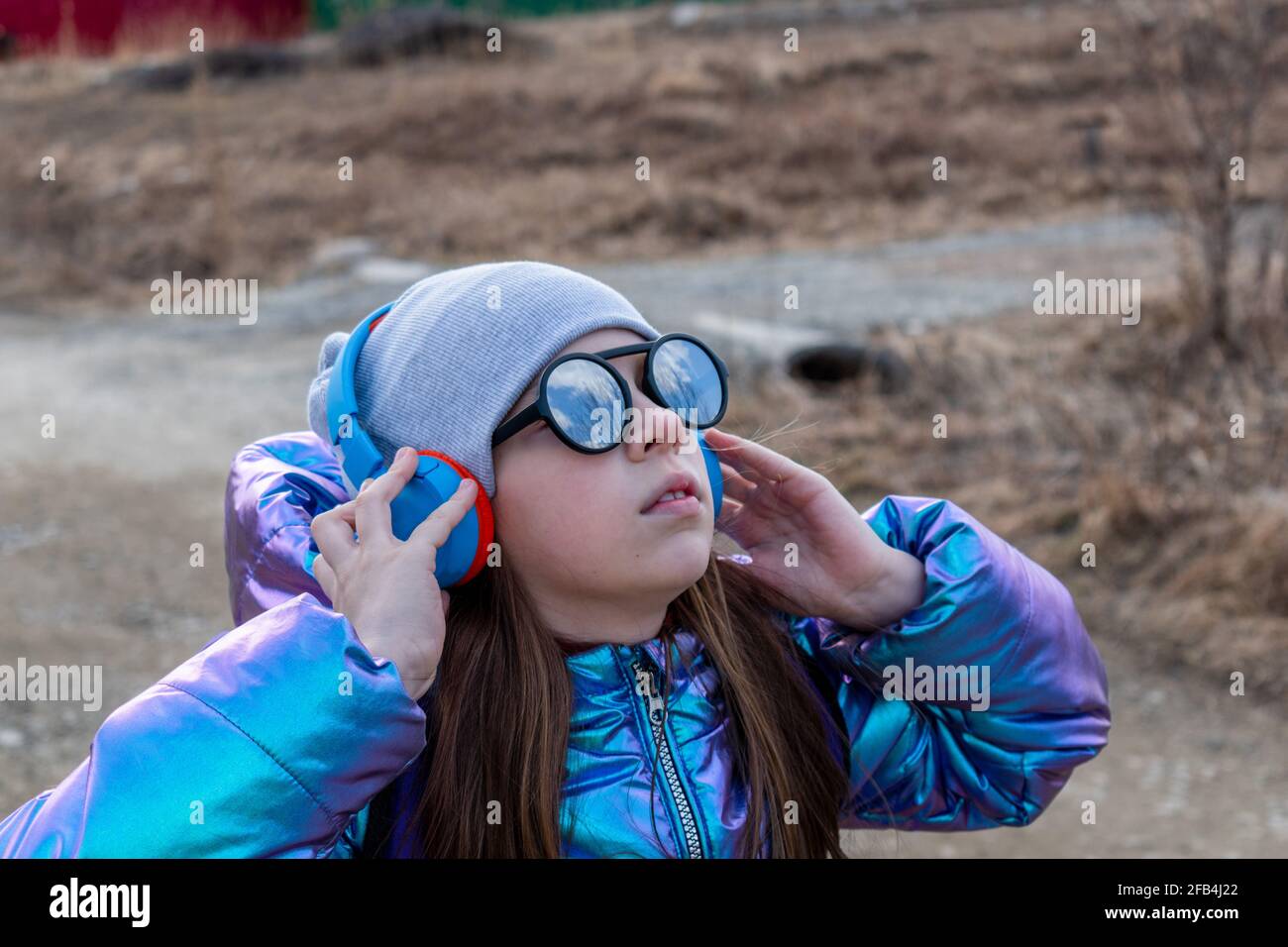 Adolescente ragazza in occhiali da sole specchiati guarda nel cielo. Concetto di benessere Foto Stock
