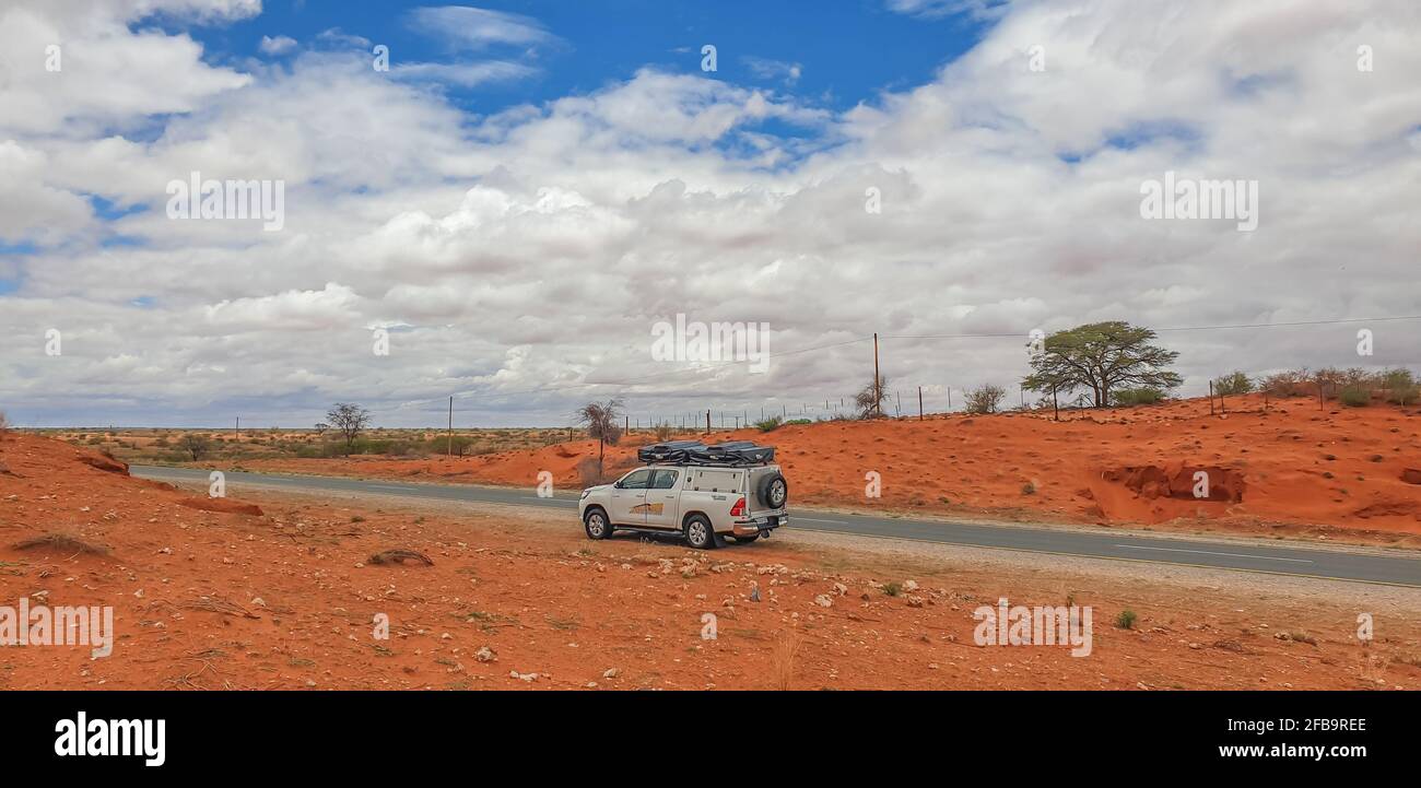KALAHARI, NAMIBIA - GENNAIO 03.2021: Paesaggio africano del deserto di Kalahari con un campeggio a quattro ruote in Namibia Foto Stock