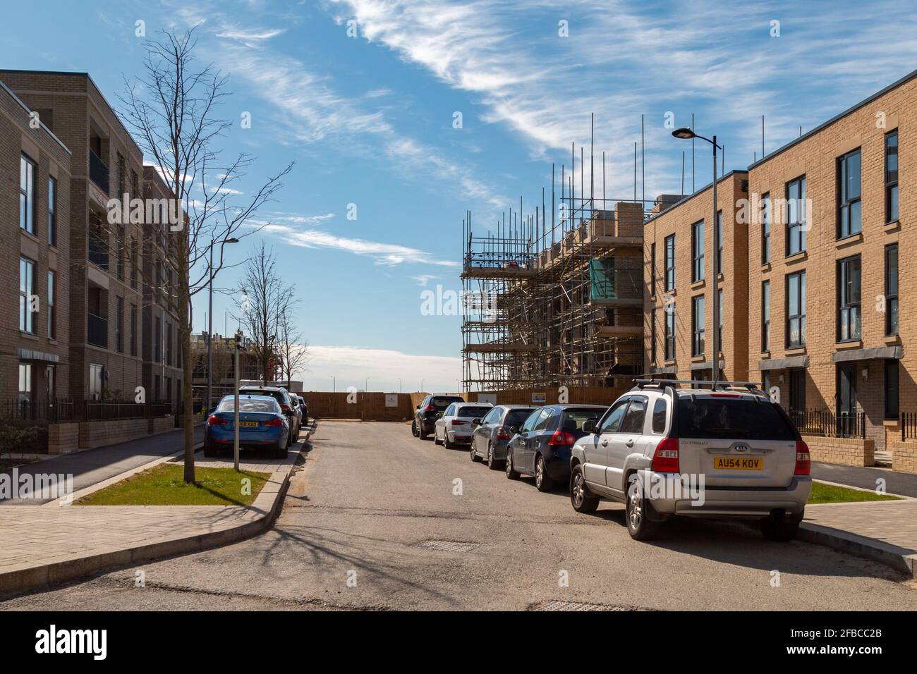 La costruzione di questo sviluppo di alloggi è in corso alla fine della strada. Foto Stock