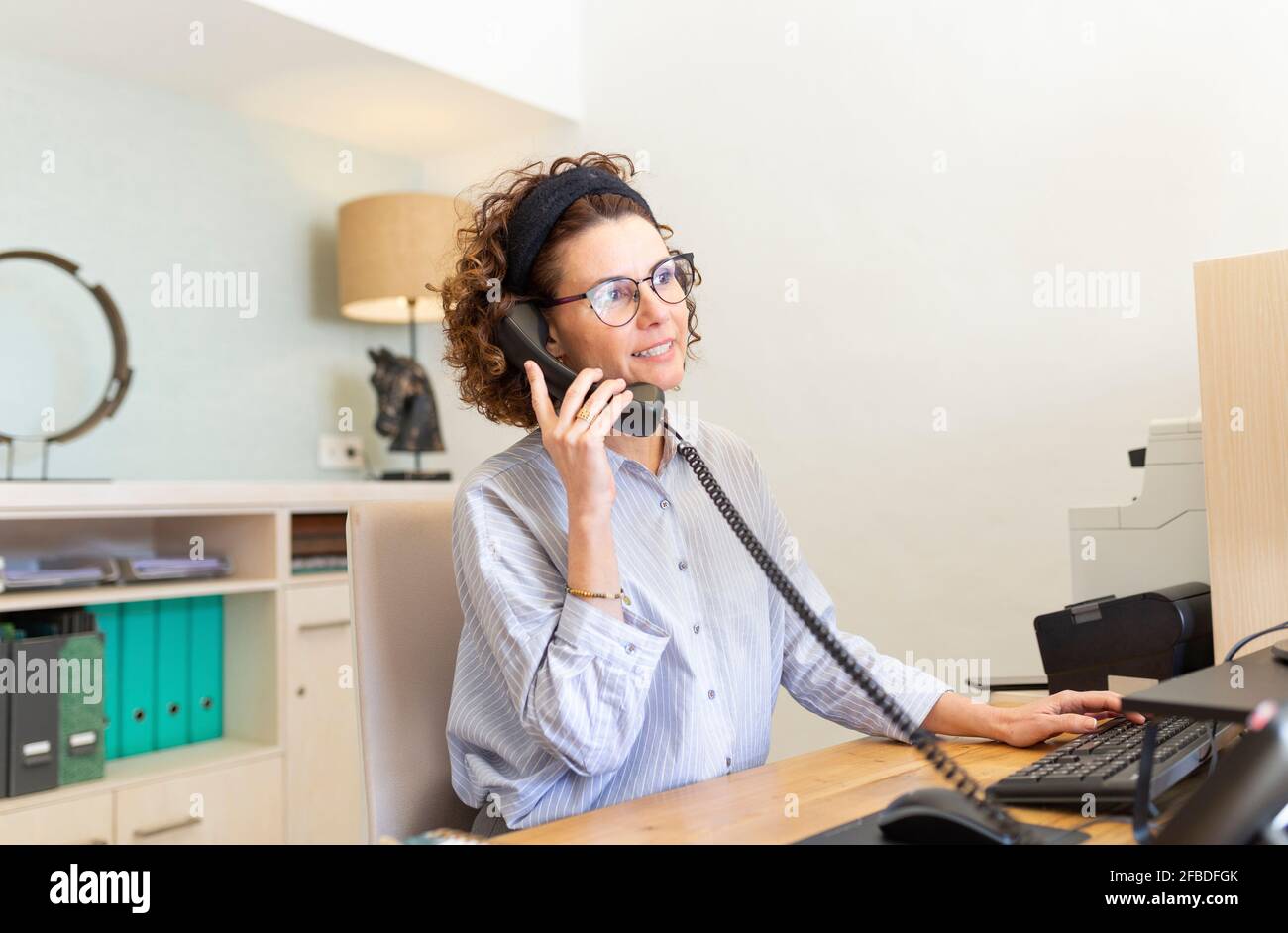 La receptionist parla al telefono alla reception dell'hotel Foto Stock
