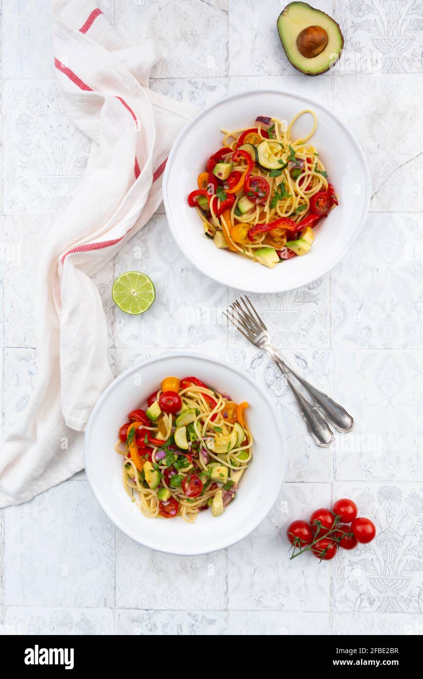 Spaghetti con verdure alla griglia, paprika, zucchine, avocado, pomodoro e coriandolo Foto Stock