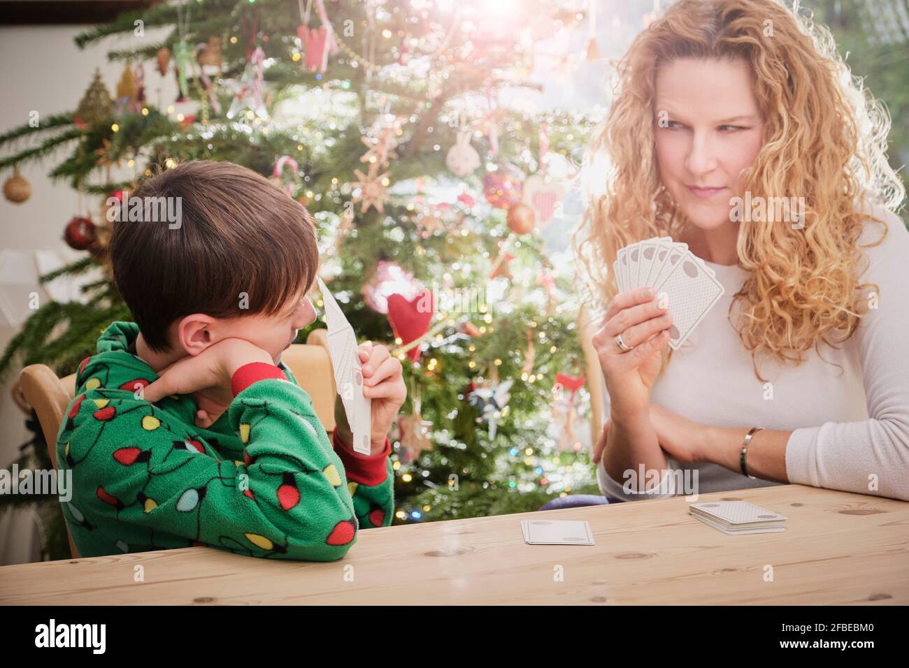 La madre ed il figlio giocano le carte al tavolo durante Natale Foto Stock