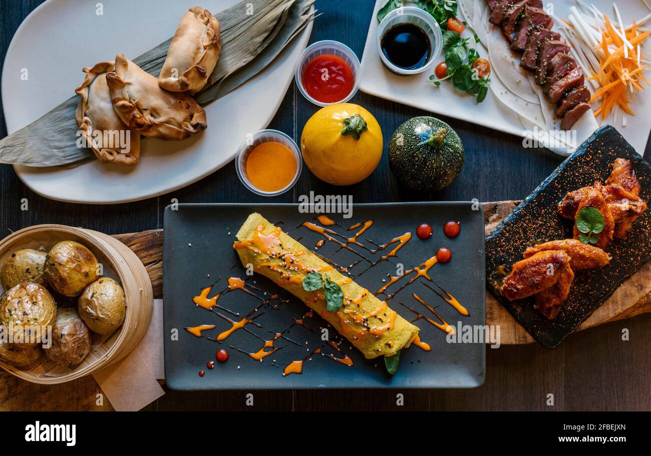 Cannelloni, pasties, patate, carne e ali serviti nel ristorante Foto Stock