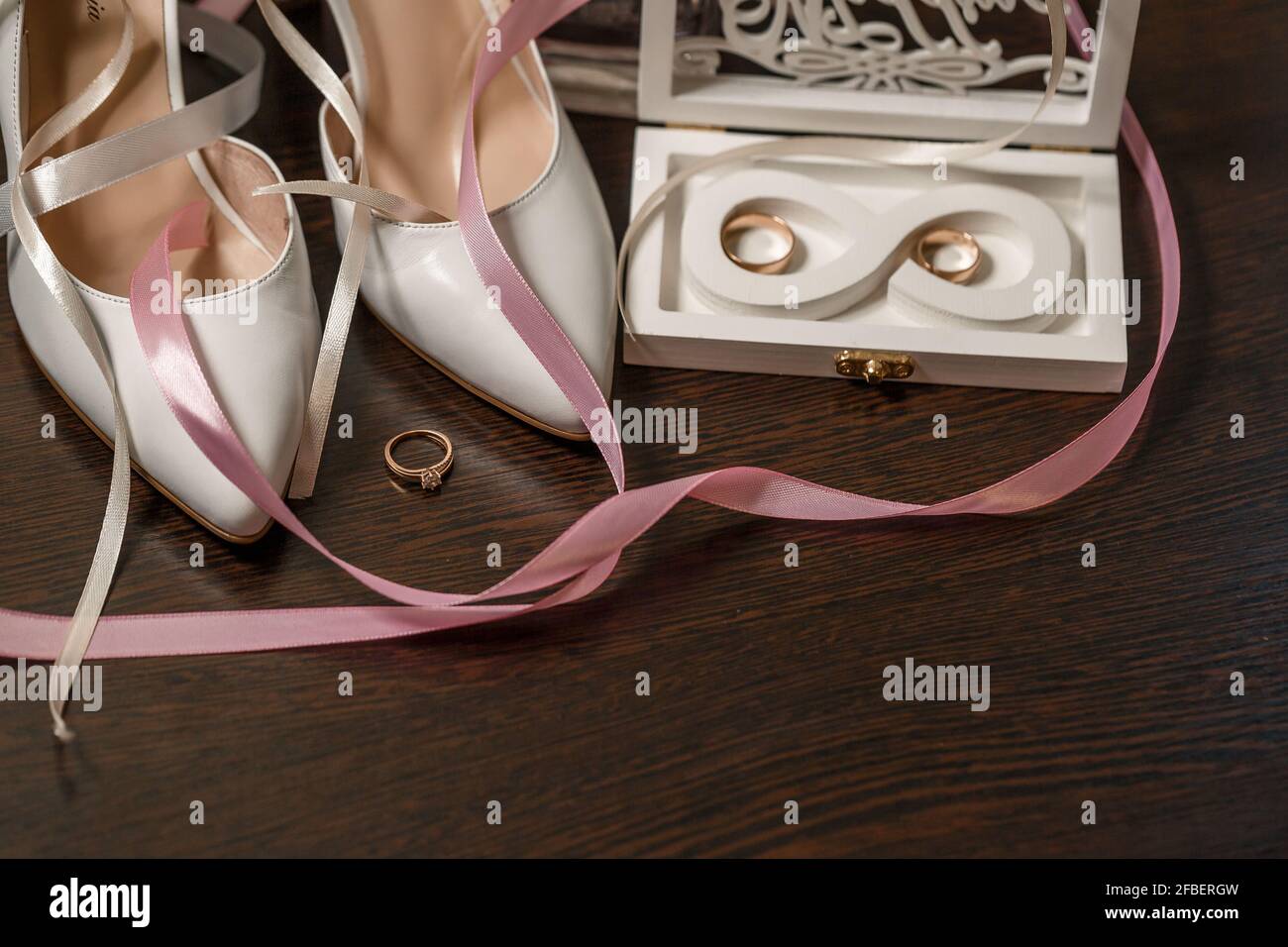 Scarpe da sposa per la sposa. Scarpe bianche con tacco alto vicino agli  anelli per matrimoni, gioielli per matrimoni. Concetto di matrimonio Foto  stock - Alamy