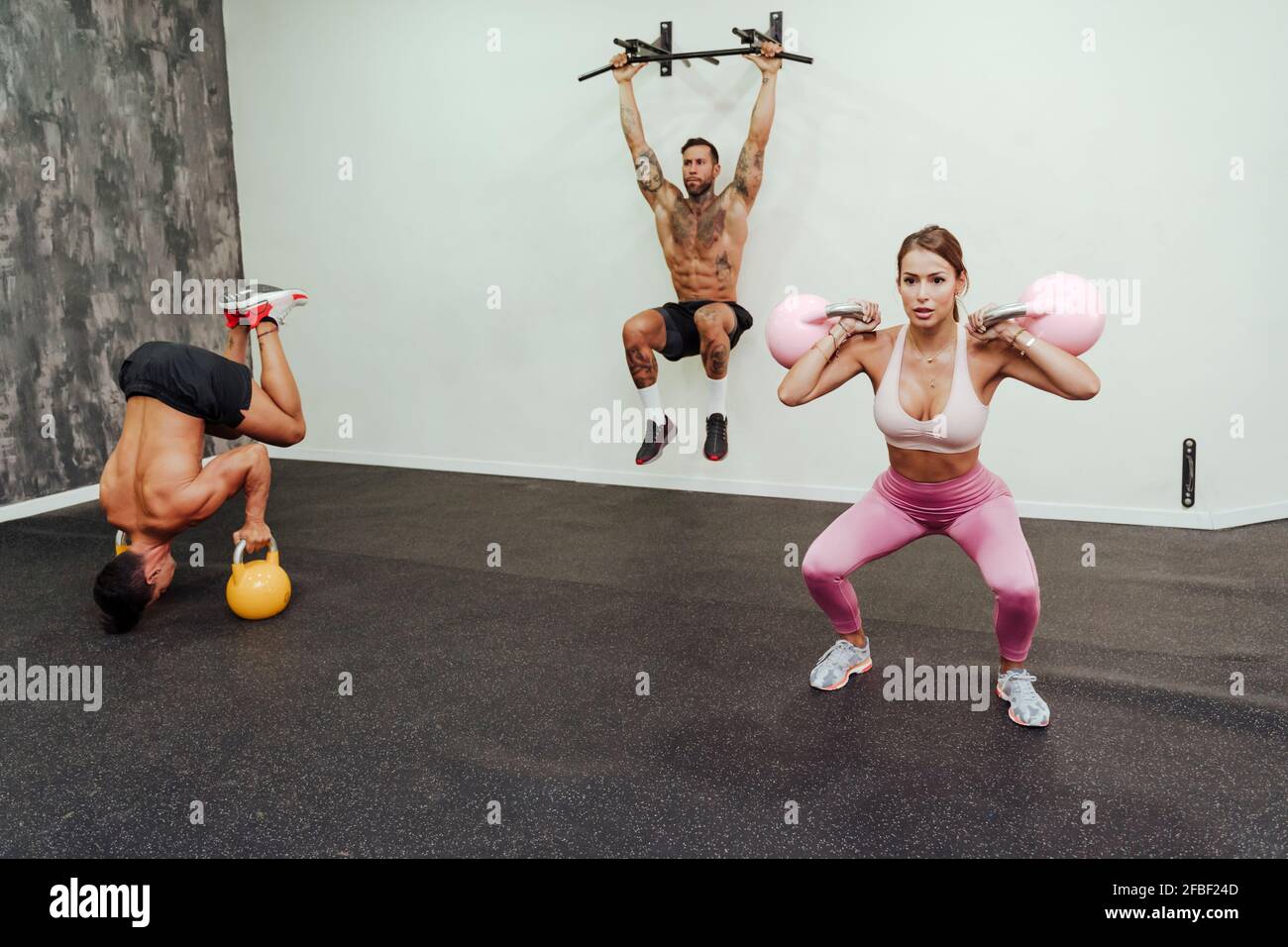 Persone sportive che si allenano con attrezzature in palestra Foto Stock Persone sportive che si allenano con attrezzature in palestra Foto Stock