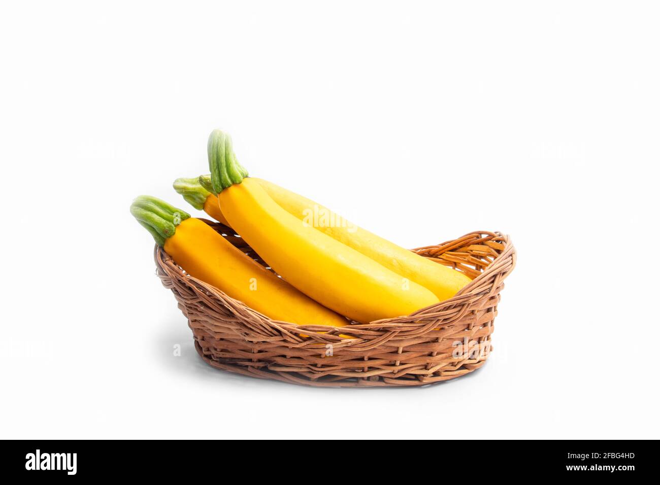 Zucca estiva Zucchini è giallo colorato Gourd anche noto come Courgette, Baby Marrow, indiano Jugni Sabzi o Jugnu petha Sabji in cestino. Isolato su Wh Foto Stock