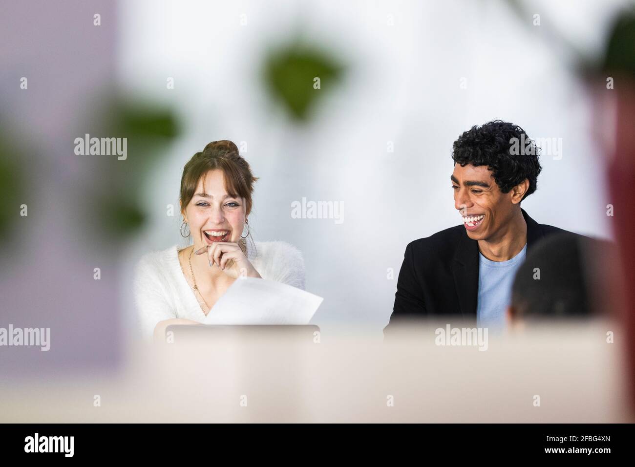 Allegri colleghi di sesso maschile e femminile in ufficio Foto Stock