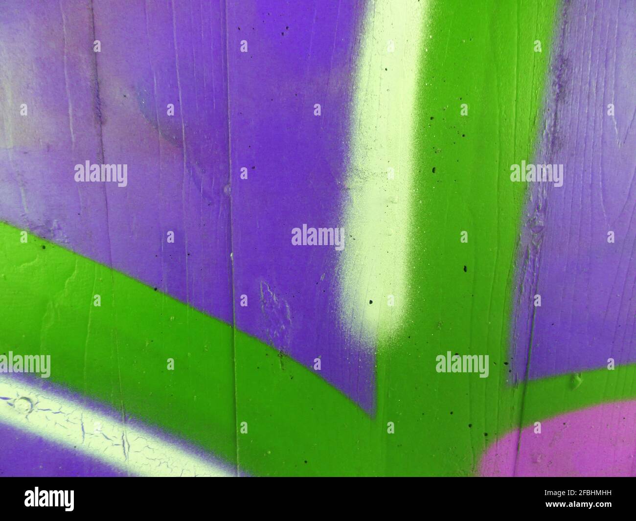 Viola, verde, rosa, bianco e giallo spruzzati su una parete di cemento Foto Stock