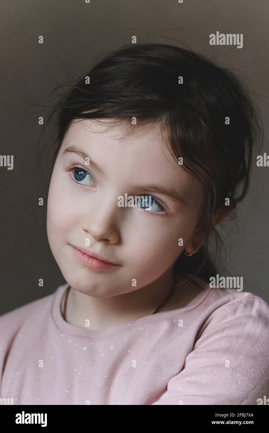 Ragazza innocente con occhi blu che guardano via Foto Stock