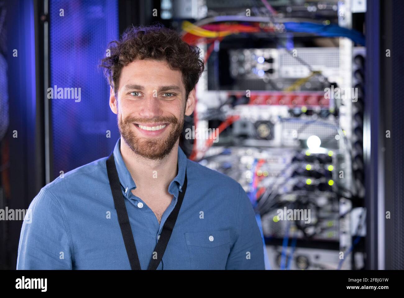 Sorridente esperienza IT maschile nel data center Foto Stock
