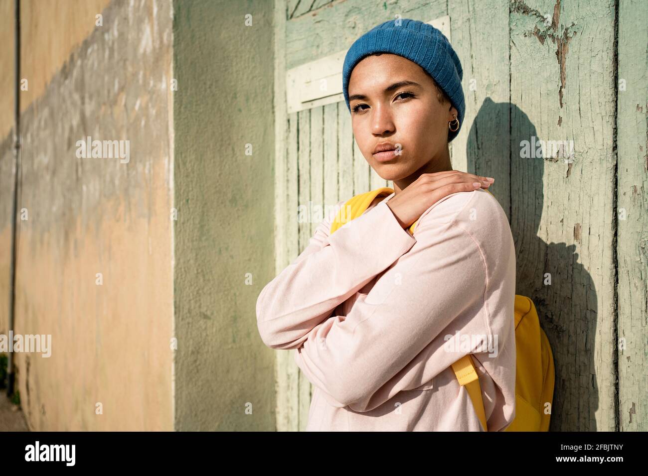 Donna che si agguanta di fronte alla vecchia porta Foto Stock