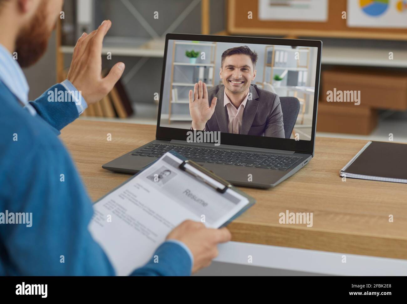 Sorridente datore di lavoro o responsabile di assunzione saluto candidato al lavoro in virtuale intervista di lavoro Foto Stock