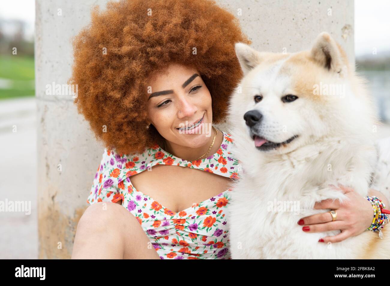 Donna sorridente che guarda un cane soffice Foto Stock