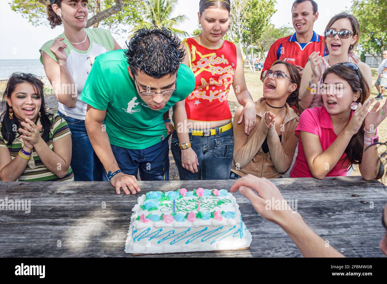 Miami Florida,Homestead Biscayne National Park,gli studenti ispanici adolescenti amici ragazzi ragazze,festeggiando la torta di compleanno che soffia fuori la candela Foto Stock