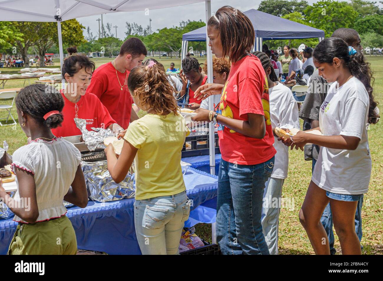 Miami Florida,Tropical Park Droga Free Youth in Town DFYIT,teen Student anti addiction group picnic,buffet style line table food Black Ispan Boys gi Foto Stock