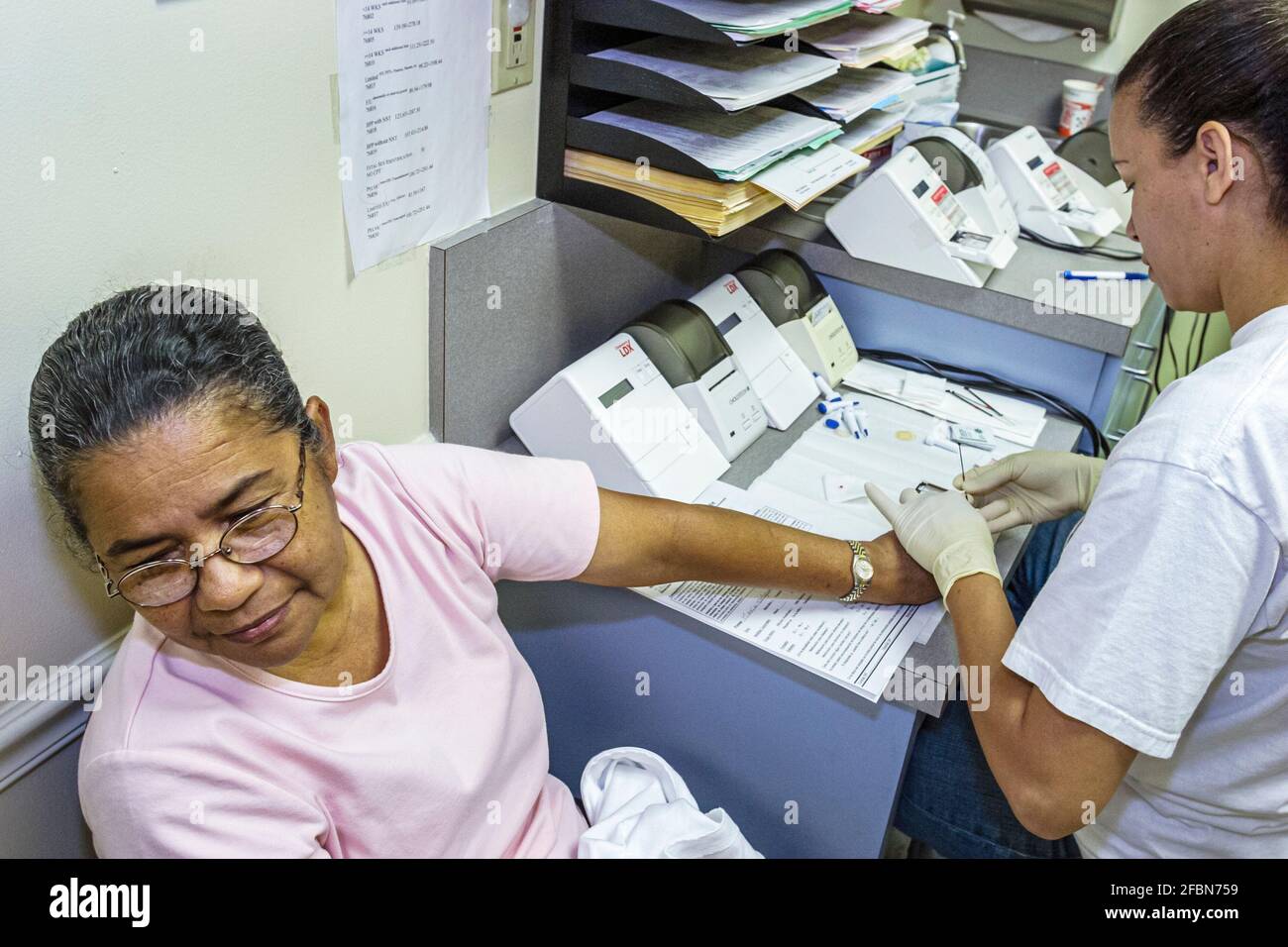 Miami Beach Florida, Centro di Salute della Comunità, donne ispaniche donne libere colesterolo prova guarda via, disegnando il sangue tecnico Foto Stock