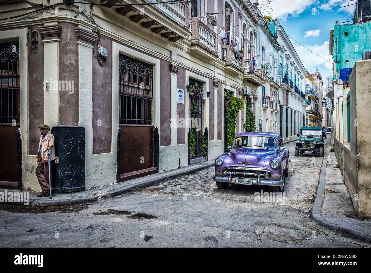 L'Avana, Cuba, luglio 2019, vista di una vecchia auto viola classica Chevrolet passando Casa Martha una pensione nella parte più antica della città Foto Stock