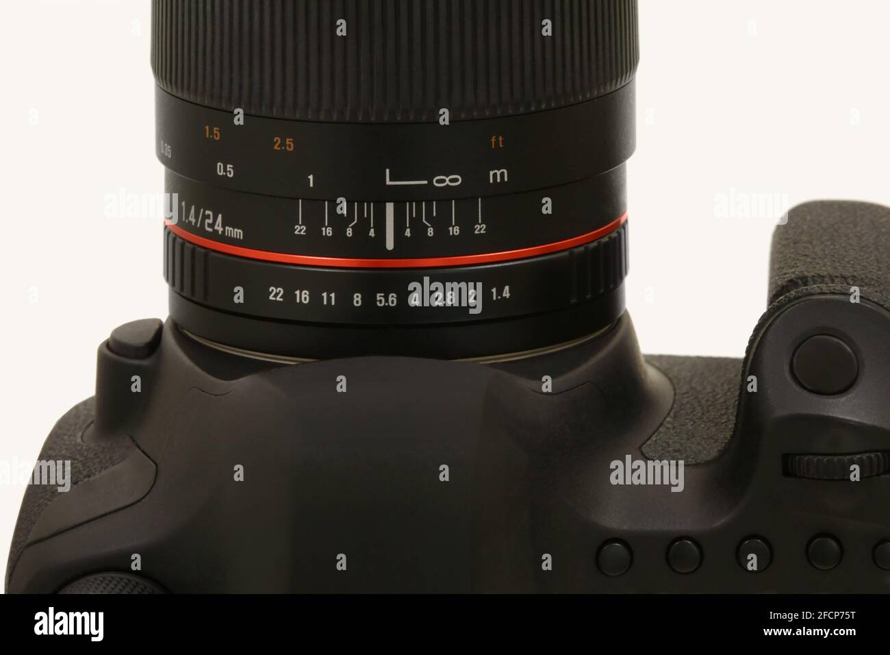 Gli anelli di apertura e di messa a fuoco sono mostrati sul cilindro di un moderno obiettivo per fotocamera DSLR, mostrato isolato in una vista macro closeup. Foto Stock