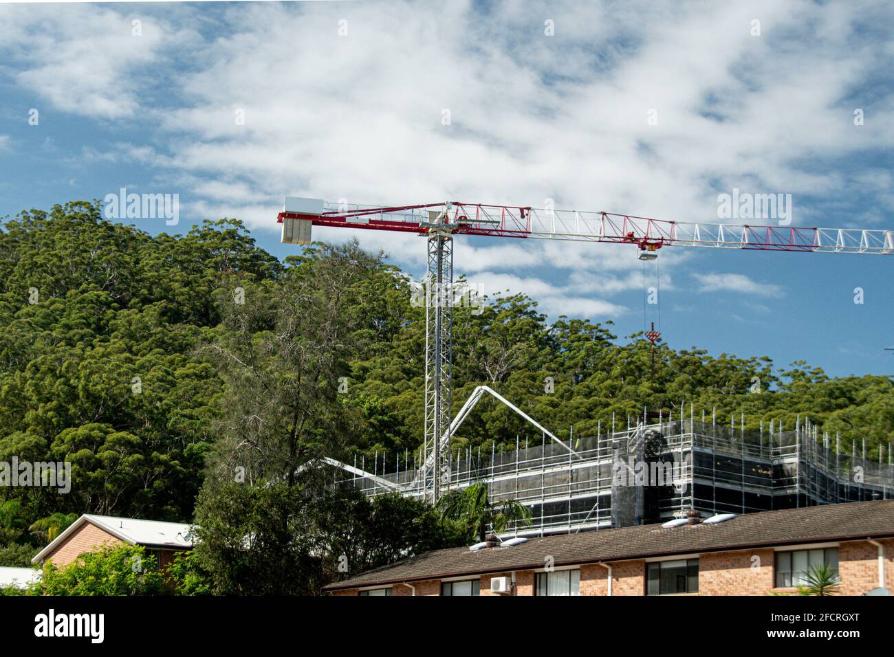 Marzo 30. 2021. Gru a torre e pompa con braccio in cemento in funzione su un nuovo cantiere con sfondo a macchia. Gosford, Australia. Foto Stock
