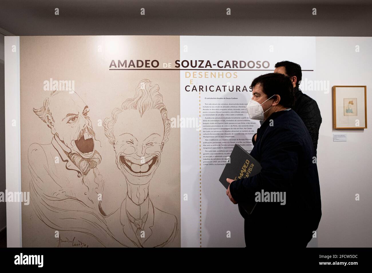 Vila Nova De Gaia, Portogallo. 23 Apr 2021. Due uomini che indossano maschere si trovano vicino alla parete principale della sala caricature mentre tengono il catalogo della mostra. La mostra, i disegni e le caricature di Amadeo de Souza-Cardoso sono stati inaugurati a Casa-Museu Teixeira Lopes/Galerias Diogo de Macedo, il più grande museo di Gaia. (Foto di Teresa Nunes/SOPA Images/Sipa USA) Credit: Sipa USA/Alamy Live News Foto Stock