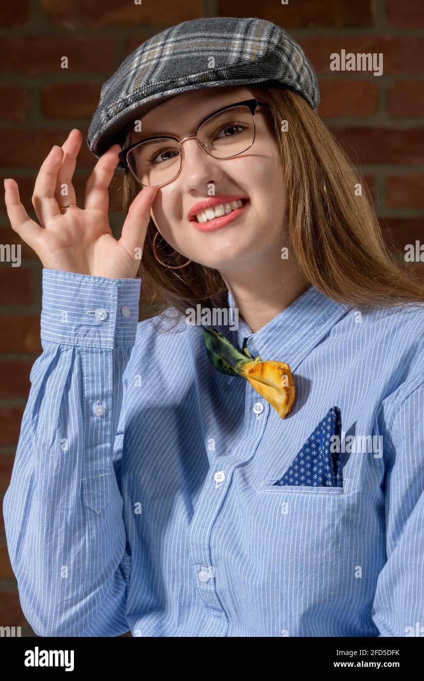 Una giovane donna carina sta posando in abiti stile uomo in studio fotografico. Foto Stock