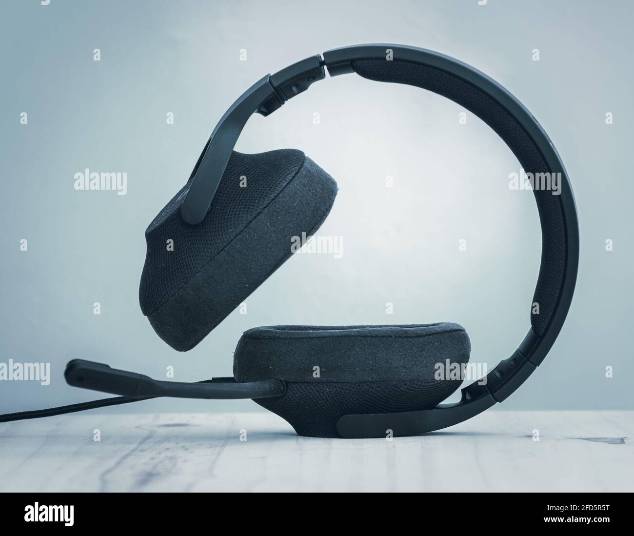 Cuffia nera per giochi con cavi staccabili, microfono e archetto regolabile, il concetto di tecnologia moderna, che si trova su un auricolare sid Foto Stock