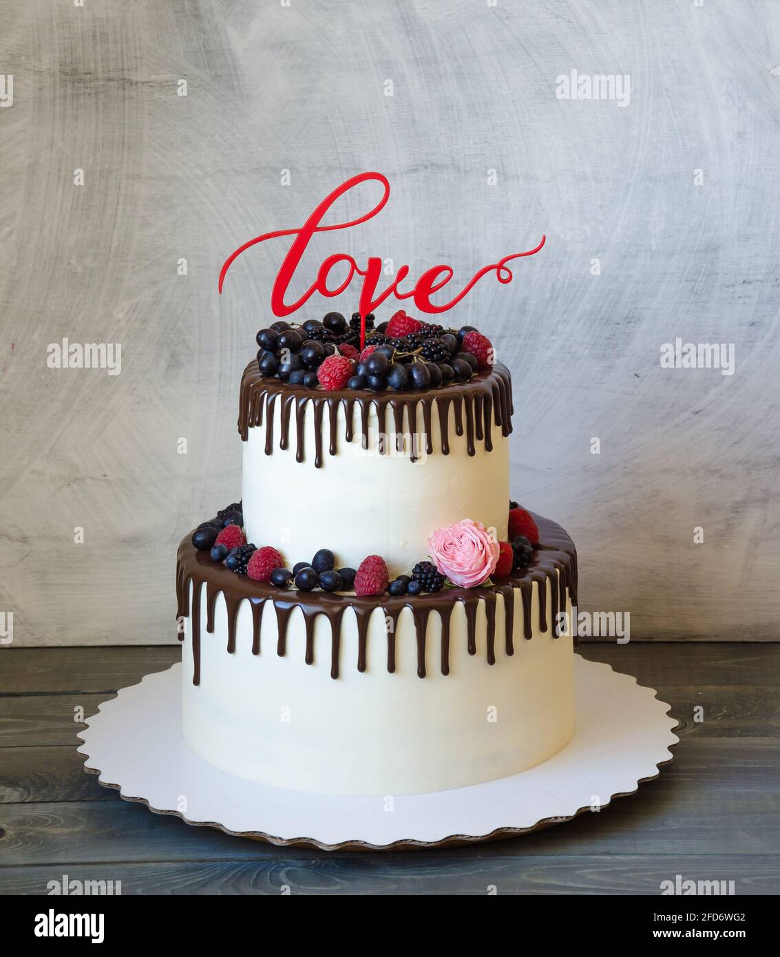 Torta a due livelli con gocce di formaggio cremoso colorato e frutti di bosco Foto Stock