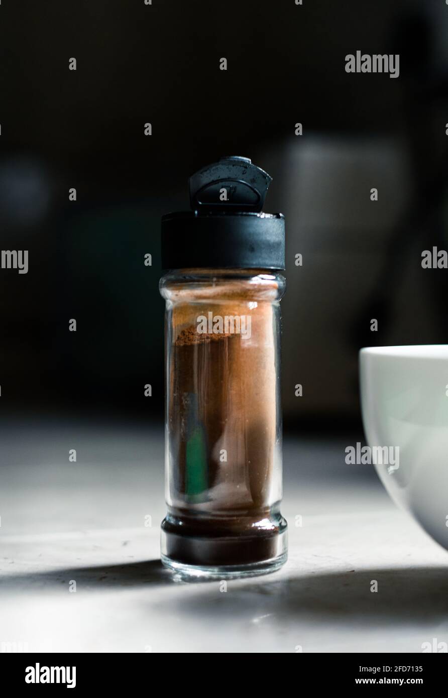 Polvere di caffè istantanea in una piccola bottiglia di vetro e in un recipiente bianco per frullare in schiuma, tempo di preparazione del caffè Dalgona in cucina a casa. Foto Stock