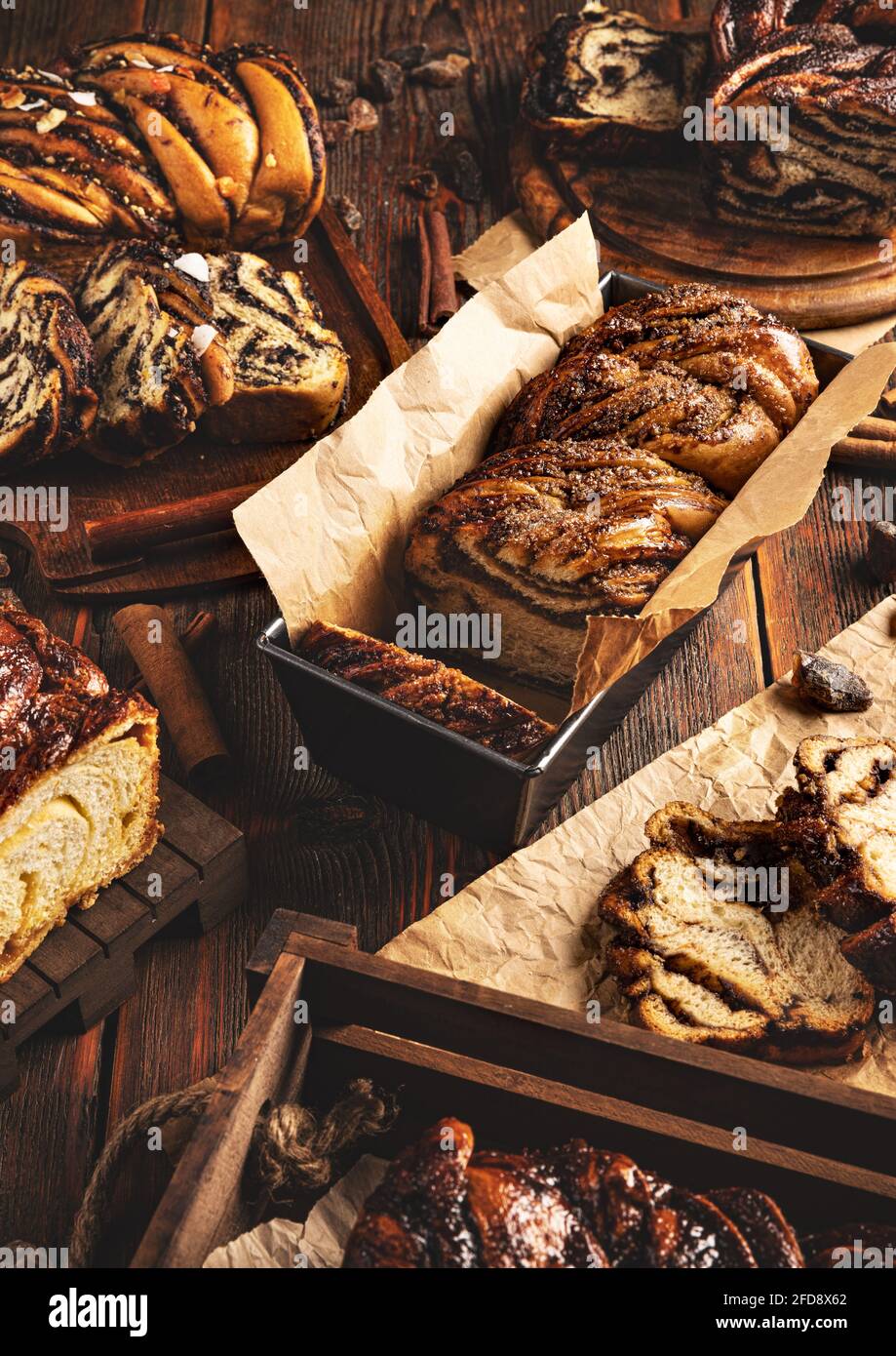 Ancora vita di vari tipi di babka dolce swirl impasto pane su sfondo di legno Foto Stock