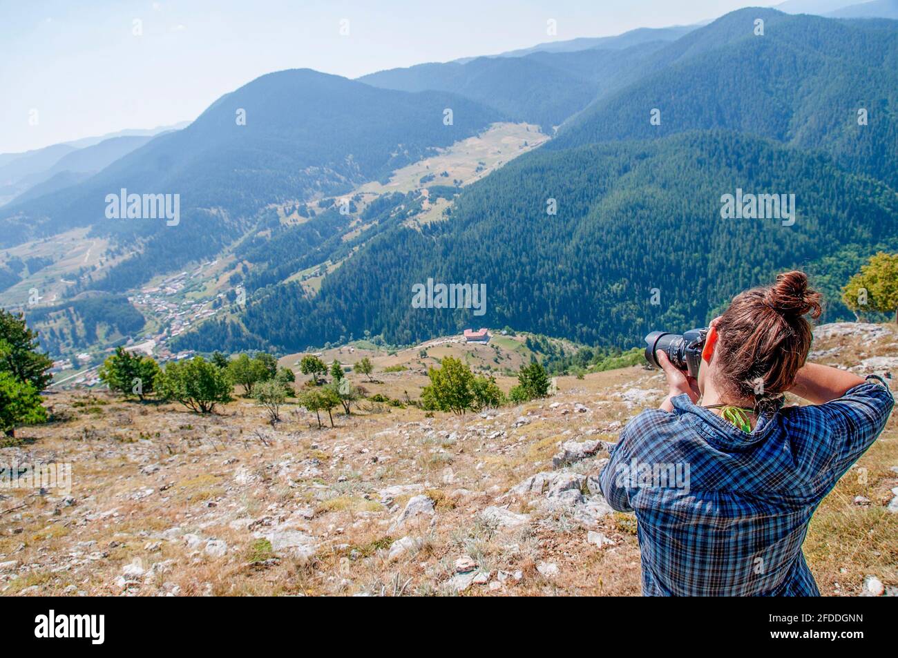 Una giovane donna che scatta una foto su una montagna. Stile di vita blogging / vlogging su vita sana, natura e all'aperto. Foto Stock
