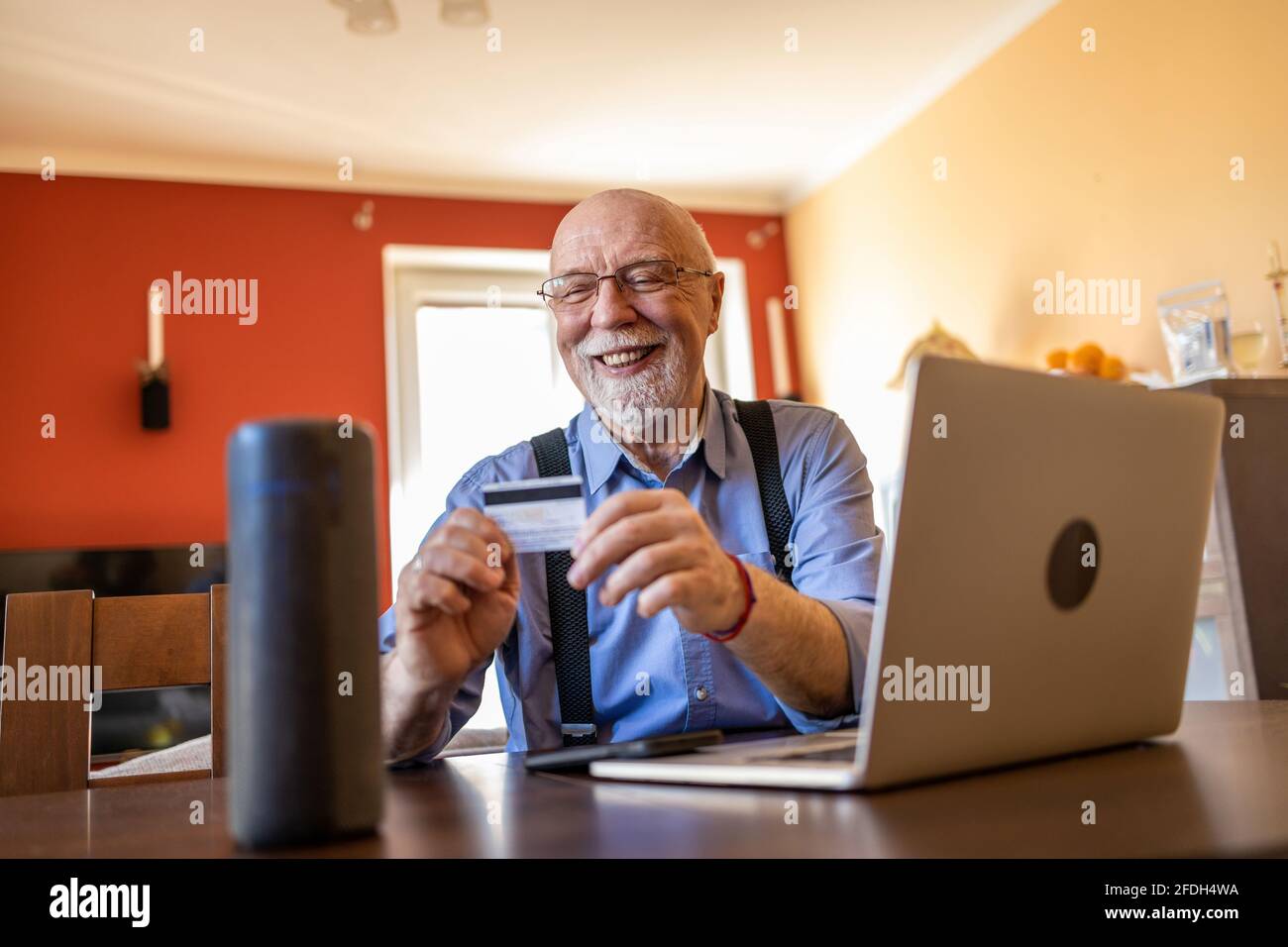 Uomo anziano che usa Virtual Assistant a casa Foto Stock