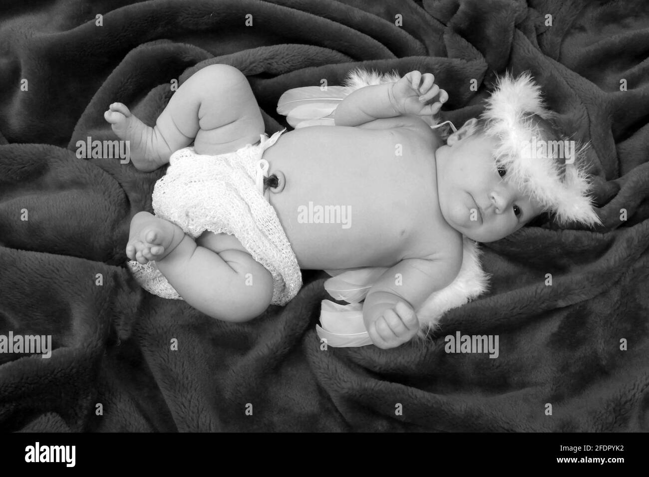 Bambina appena nata vestirsi come un angelo su morbido coperta rossa Foto Stock
