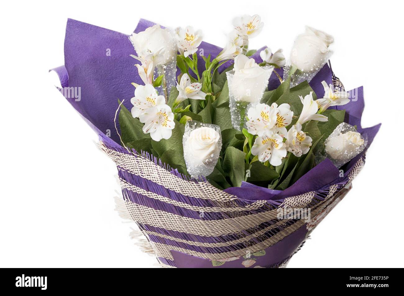 Bouquet di fiori in un primo piano involucro viola. Rose bianche e alstroemeria bianca in un bouquet di lusso. Foto Stock