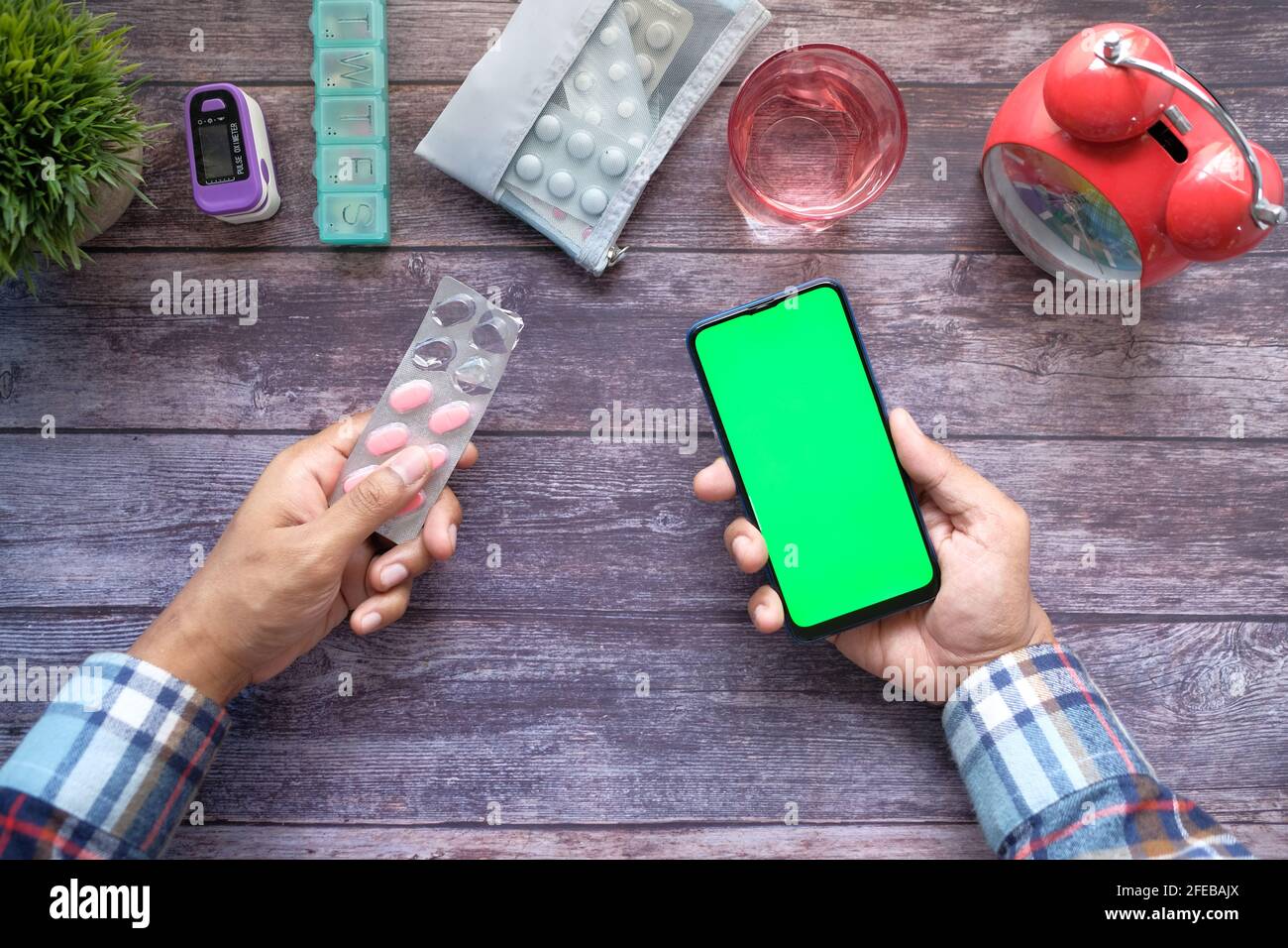 vista dall'alto di confezioni blister con supporto manuale e smartphone sul tavolo Foto Stock