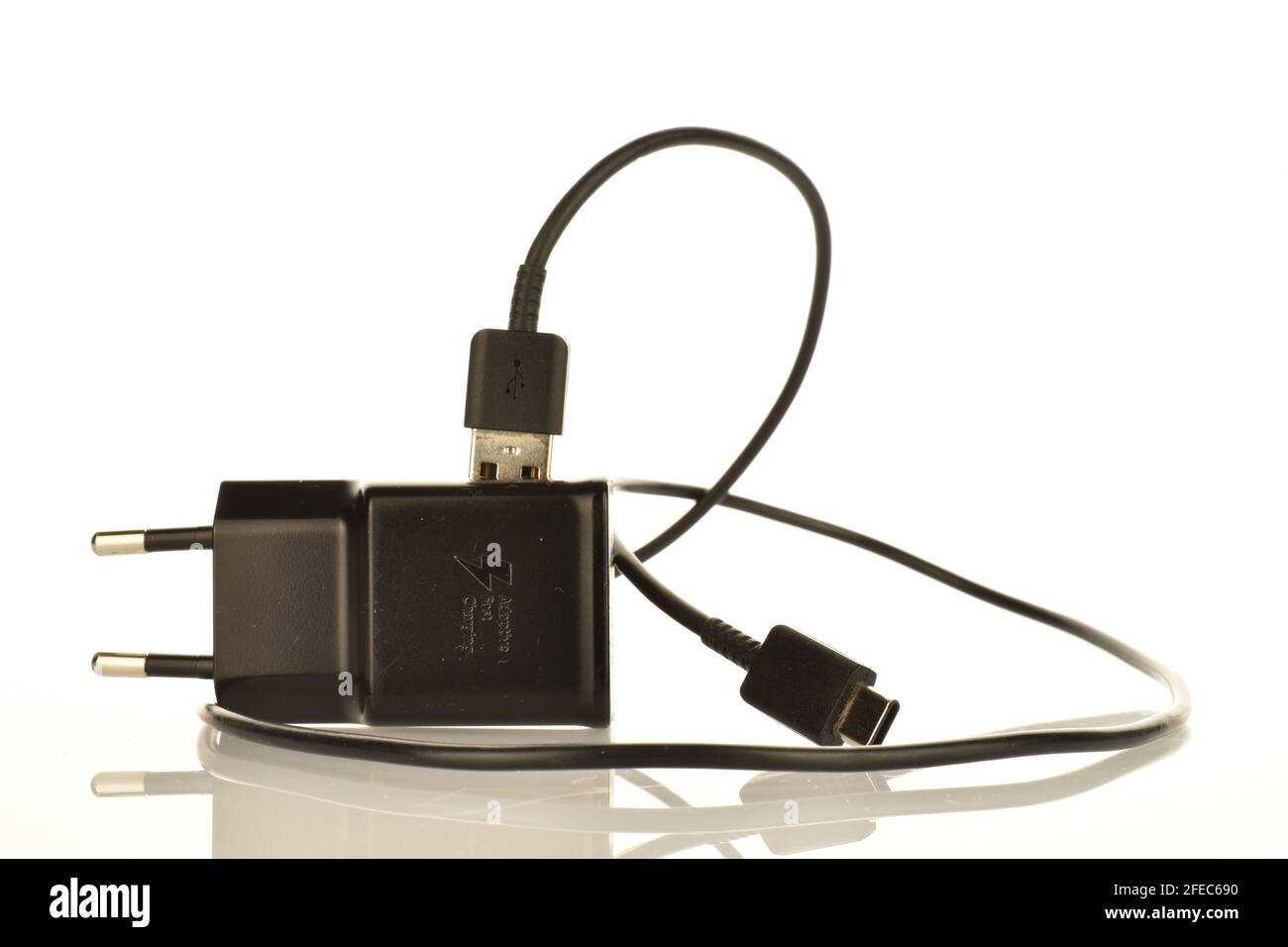 Un caricabatteria nero, primo piano, isolato su bianco. Foto Stock