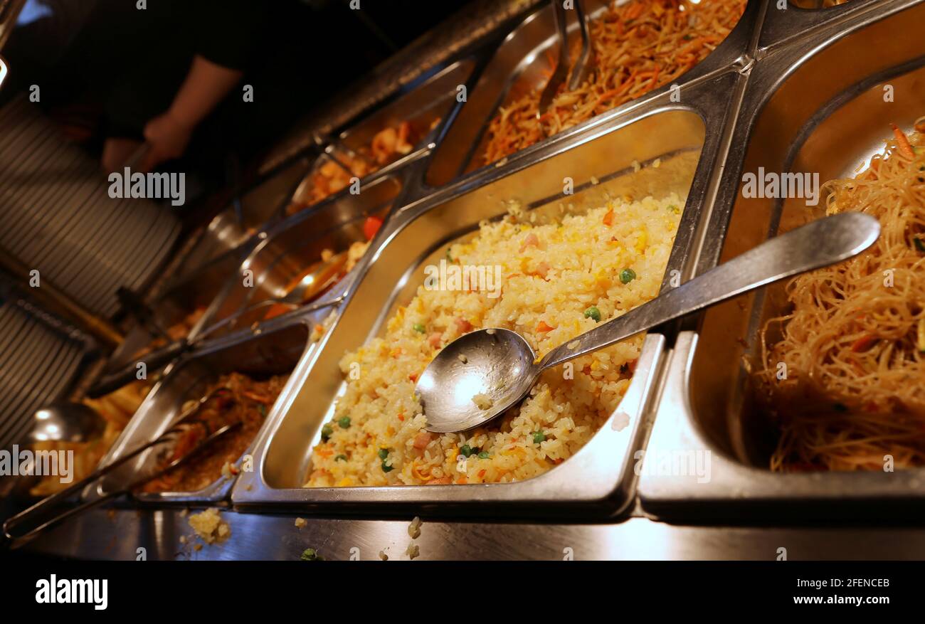 Riso e altri pasti pronti in un take away asiatico ristorante con vassoi in acciaio Foto Stock