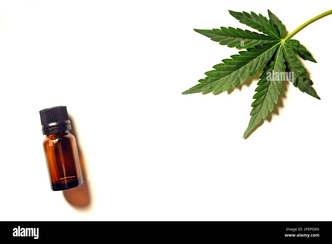 Olio di marijuana e foglia di cannabis. Bottiglia di burro isolata su fondo bianco. Medicina alternativa. Ricreazione della canapa, uso medico, legalizzazione. Foto Stock